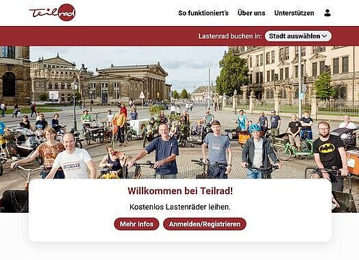 Ein Screenshot der Internetseite des Onlinebuchungsportals für Lastenräder "Teilrad". Viele Personen stehen mit unterschiedlichen Lastenrädern auf einem großen Platz.